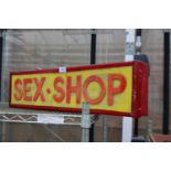 AN ILLUMINATED SEX SHOP SIGN