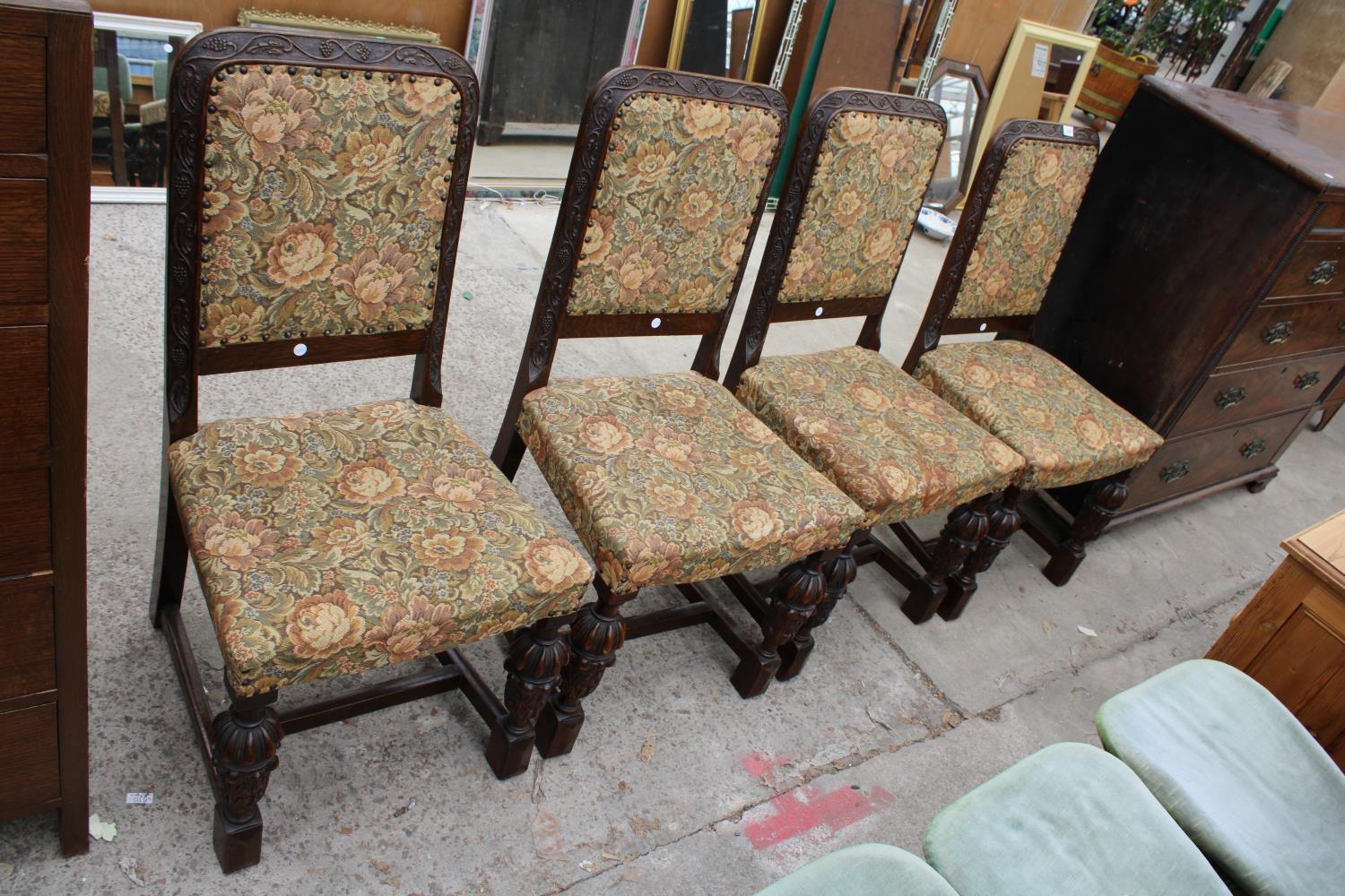 A SET OF FOUR OAK JACOBEAN STYLE DINING CHAIRS WITH BULBOUS FRONT LEGS AND FOLIATE CARVING TO BACK