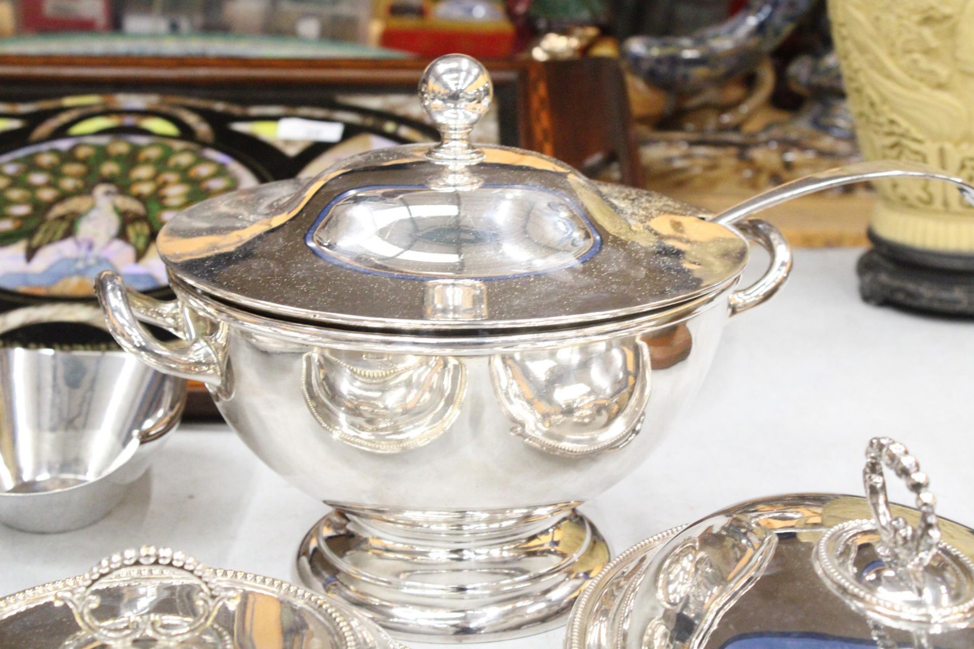 A QUANTITY OF SILVER PLATED ITEMS TO INCLUDE A SOUP TUREEN WITH LADEL, THREE LIDDED SERVING DISHES - Image 2 of 7