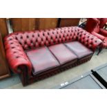 AN OXBLOOD THREE SEATER CHESTERFIELD SETTEE