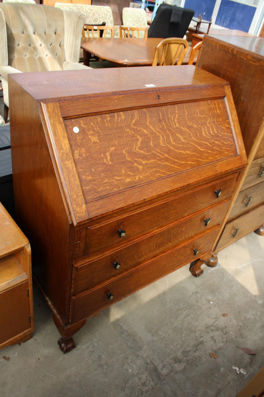 AN OAK EARLY 20TH CENTURY BUREAU WITH FITTED INTERIOR, THREE DRAWERS TO BASE ON CABRIOLE LEGS WITH