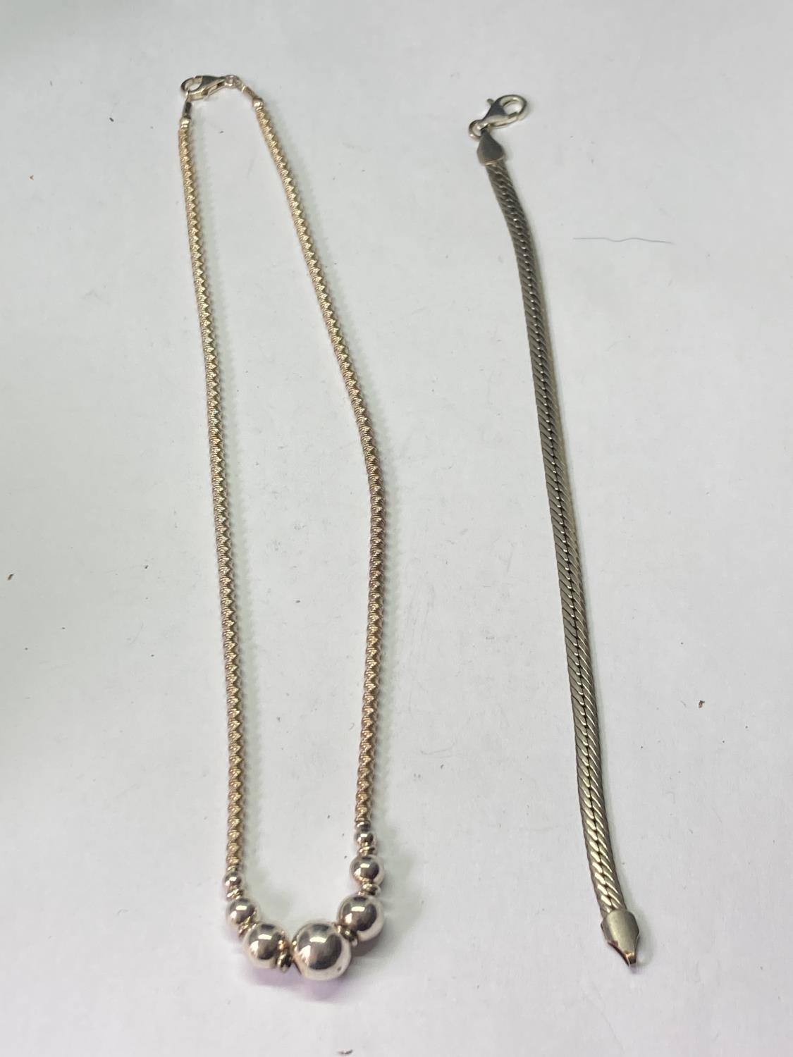 A SILVER NECKLACE AND SILVER BRACELET
