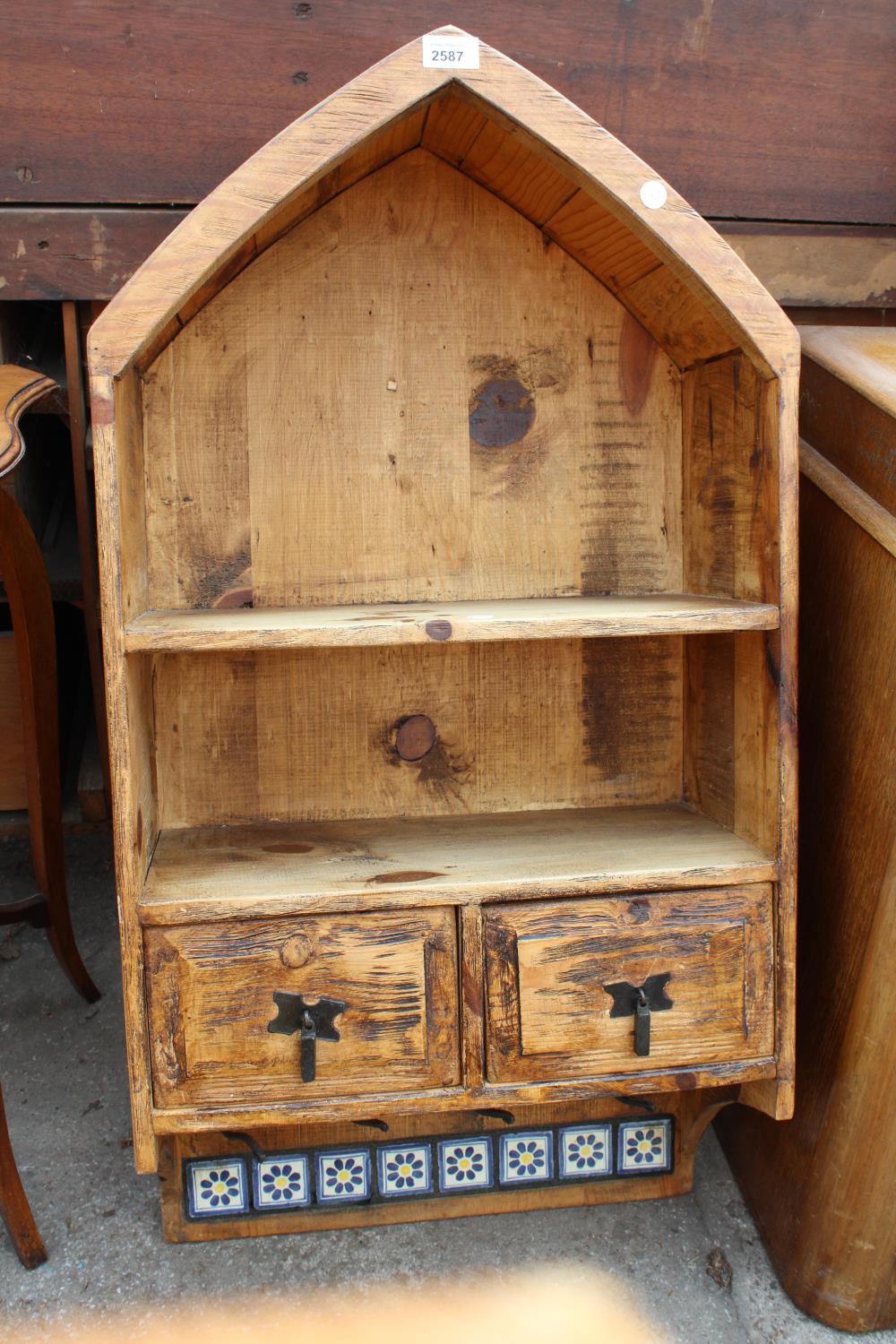 A RUSTIC PINE WALL SHELF WITH ARCHED TOP, TWO DRAWERS AND TILED BOTTOM RAIL WITH HOOKS, 19" WIDE