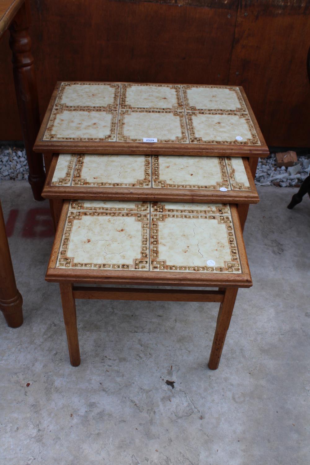 A RETRO TEAK NEST OF THREE TABLES WITH TILED TOPS, STAMPED ANBERCRAFT SHERATON HOWE