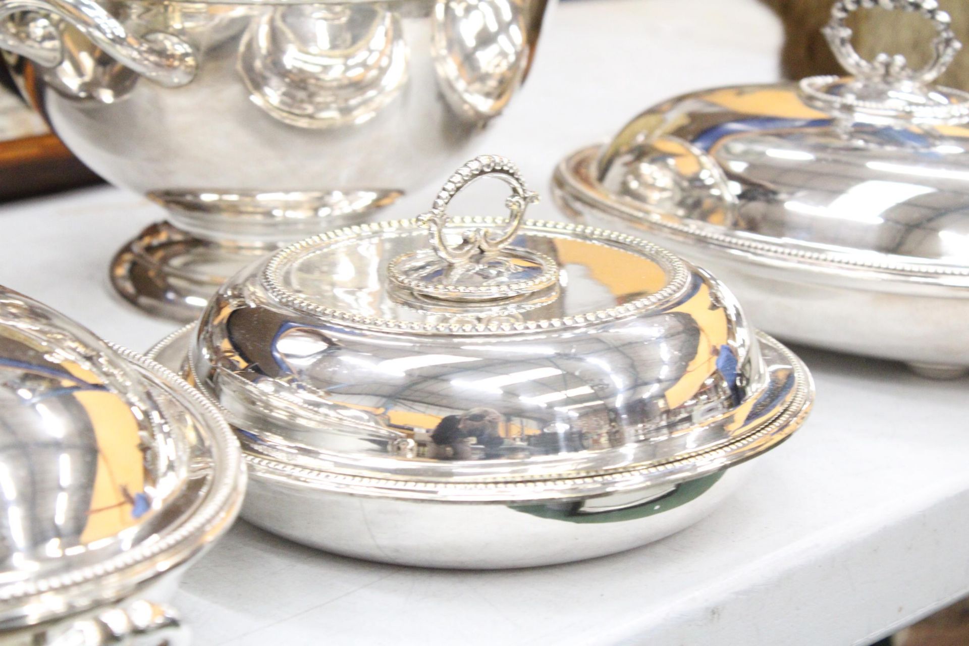A QUANTITY OF SILVER PLATED ITEMS TO INCLUDE A SOUP TUREEN WITH LADEL, THREE LIDDED SERVING DISHES - Image 4 of 7