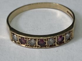 A 9 CARAT GOLD RING WITH THREE GARNETS AND FOUR CUBIC ZIRCINIAS IN A LINE SIZE T/U