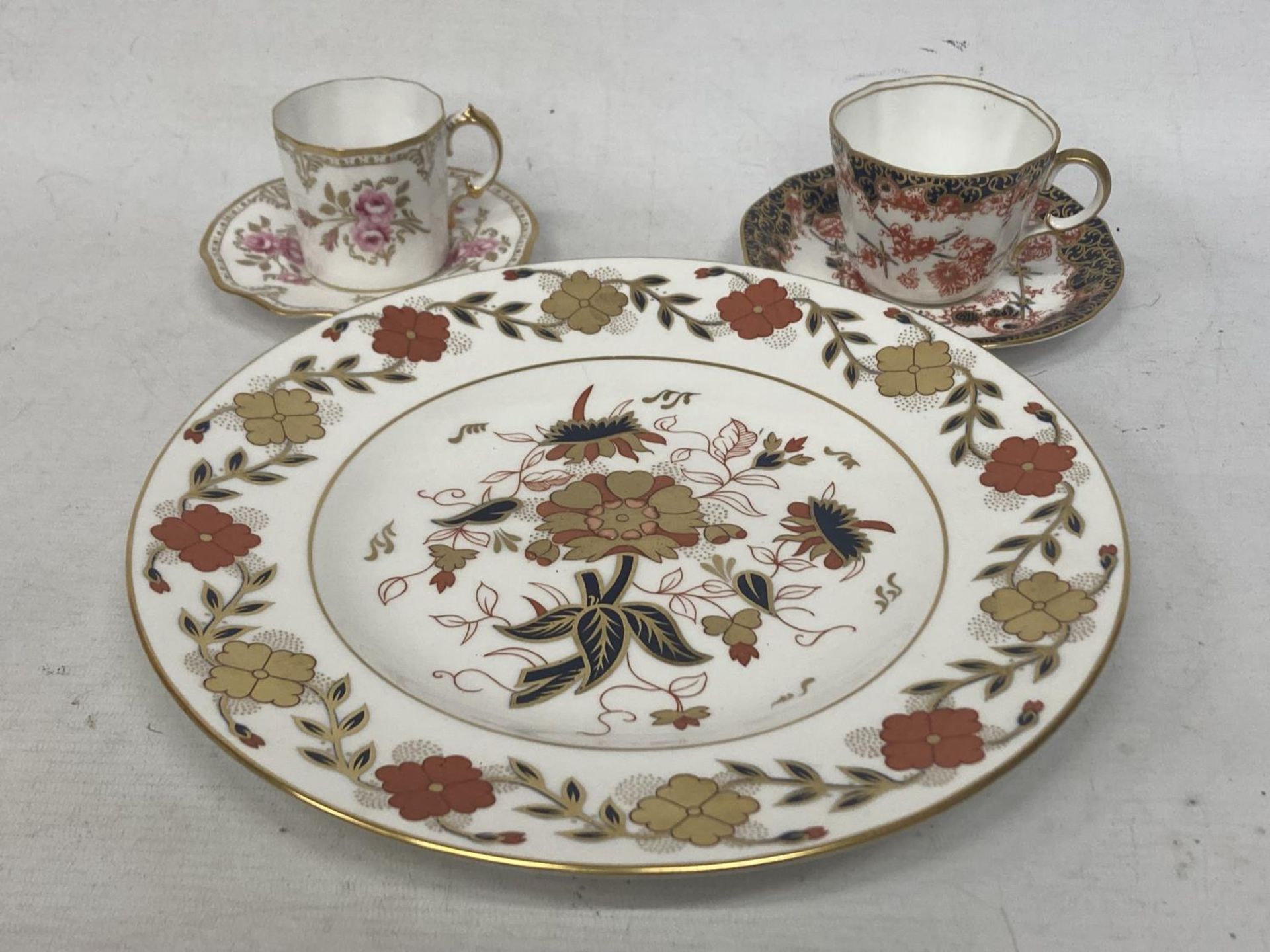 A ROYAL CROWN DERBY PINXTON ROSES COFFEE CAN AND SAUCER TOGETHER WITH A ROYAL CROWN DERBY TEACUP AND