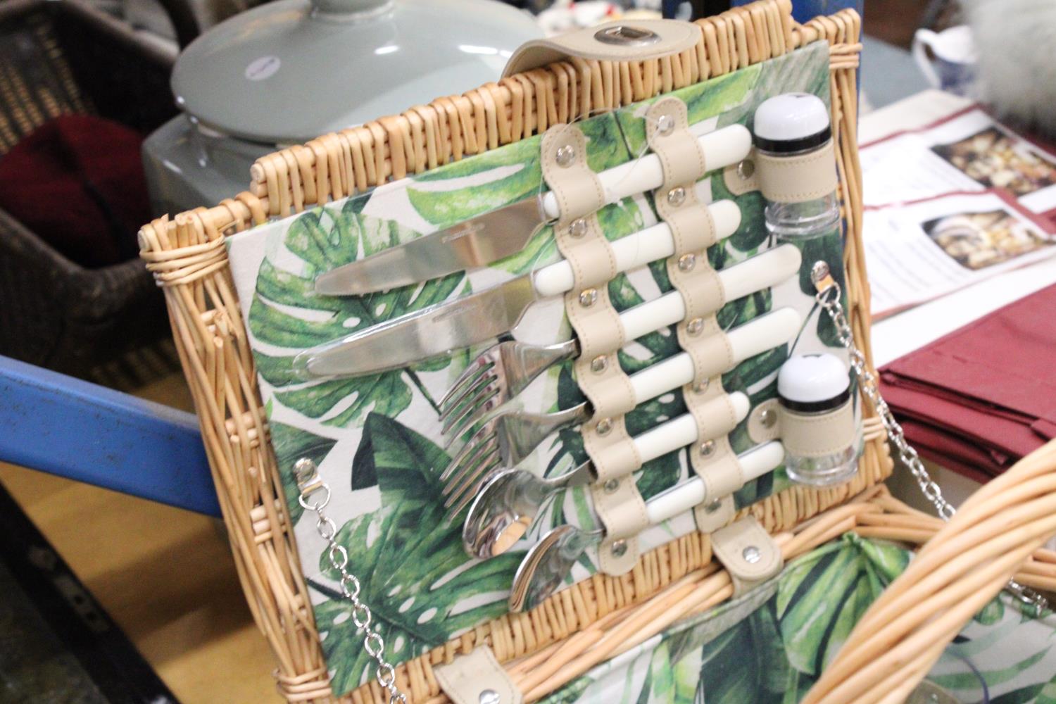 A WICKER PICNIC BASKET WITH LEAF PATTERN INTERIOR TO INCLUDE KNIVES, FORKS, SPOONS, PLATES, SALT AND - Image 2 of 7