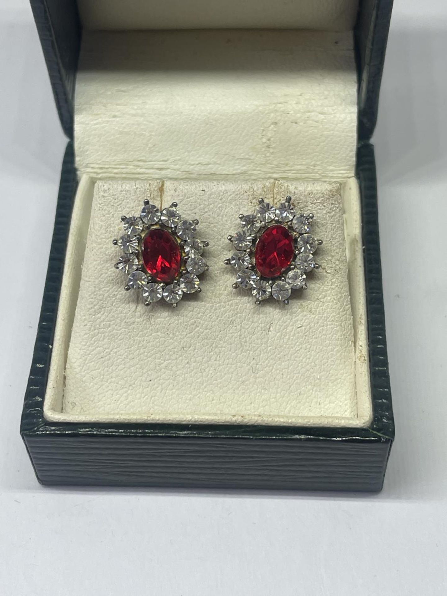 A PAIR OF SILVER AND RED STONE EARRINGS IN A PRESENTATION BOX