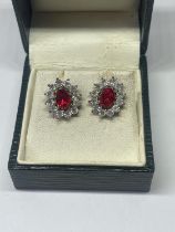 A PAIR OF SILVER AND RED STONE EARRINGS IN A PRESENTATION BOX