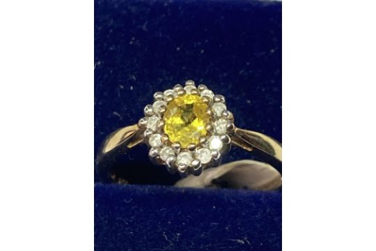 A 9 CARAT GOLD RING WITH CENTRECITRINE SURROUNDED BY CLEAR STONES SIZE K/L IN A PRESENTATION BOX - Image 2 of 4