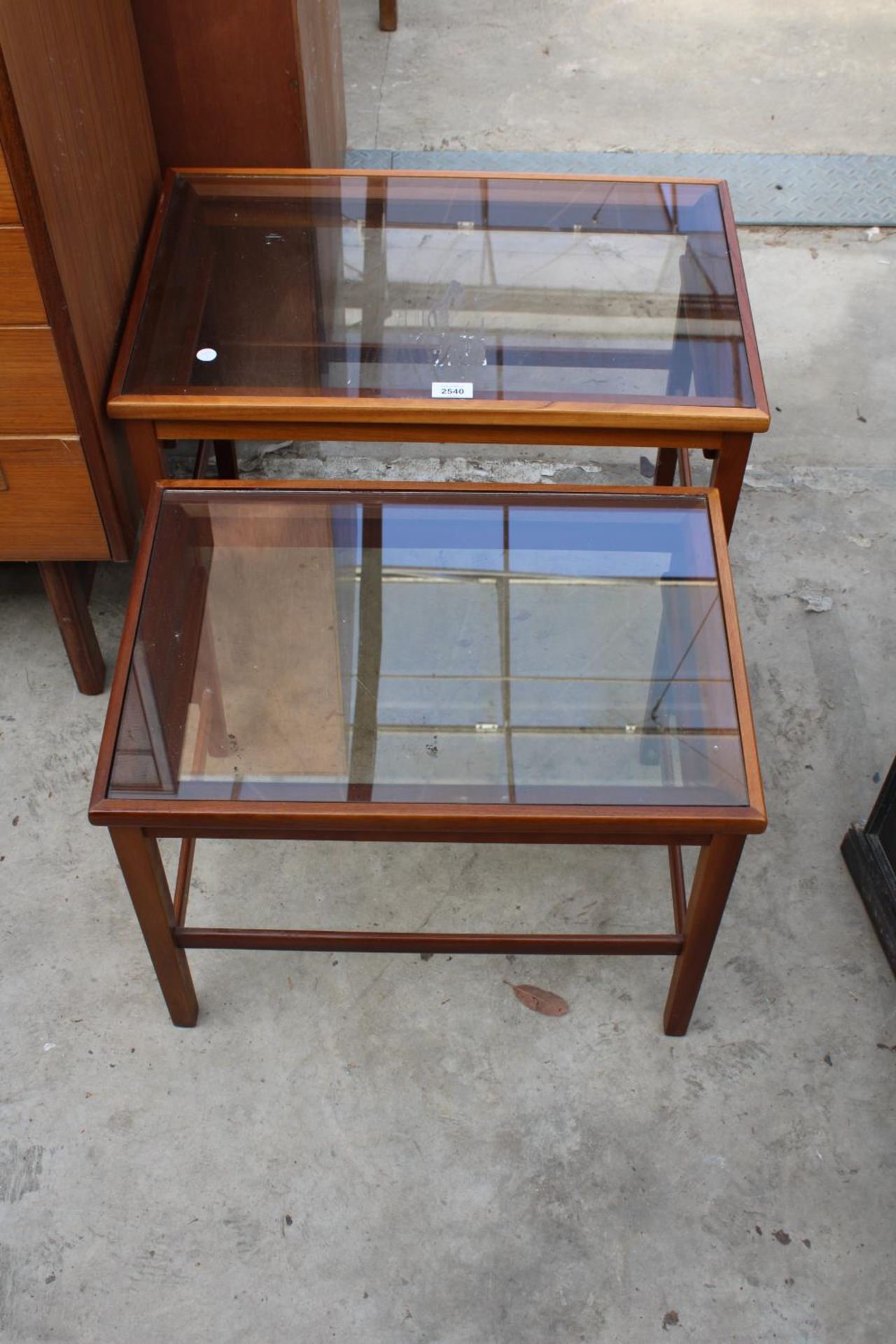 A RETRO TEAK NEST OF TWO TABLES WITH INSET GLASS TOPS