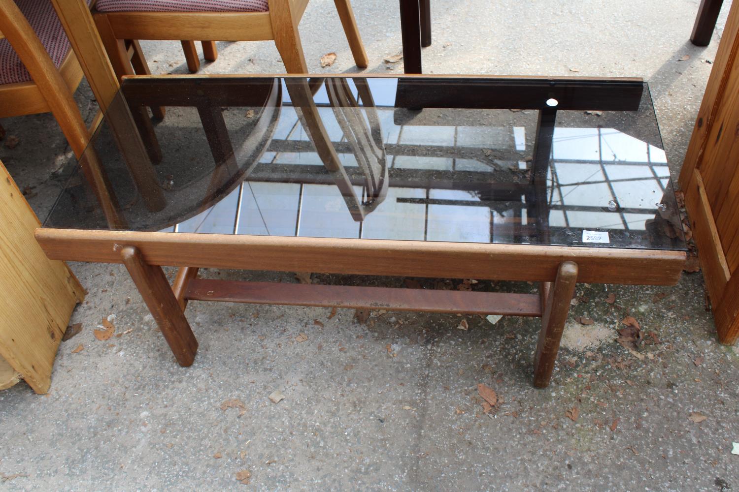 A RETRO TEAK TWO TIER COFFEE TABLE WITH SMOKED GLASS TOP, 39.5" X 17"