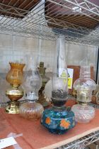 AN ASSORTMENT OF VINTAGE OIL LAMPS WITH SHADES AND FUNNELS, TO INCLUDE TWO CONVERTED TO ELECTRIC