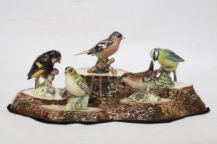 A BESWICK TREE STUMP STAND WITH A COLLECTION OF SMALL BESWICK BIRDS TO INCLUDE A CHAFFINCH, BLUE