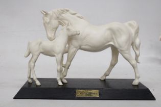 A BESWICK SPIRIT OF AFFECTION MATT WHITE MARE AND FOAL ON A BLACK WOODEN PLINTH