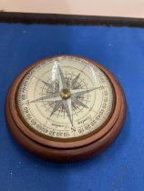 A WOODEN PAPERWEIGHT COMPASS