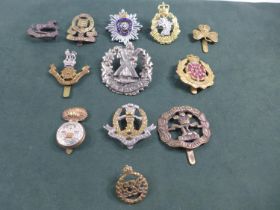 A COLLECTION OF TWELVE MILITARY BADGES TO INCLUDE SOUTH LANCASHIRE, LOYAL REGIMENT ETC.