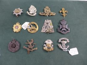 A COLLECTION OF TWELVE MILITARY BADGES TO INCLUDE ROYAL ARTILLERY, SOUTH WALES BORDERERS ETC.