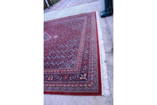 A LARGE RED PATTERNED FRINGED RUG - Image 3 of 6