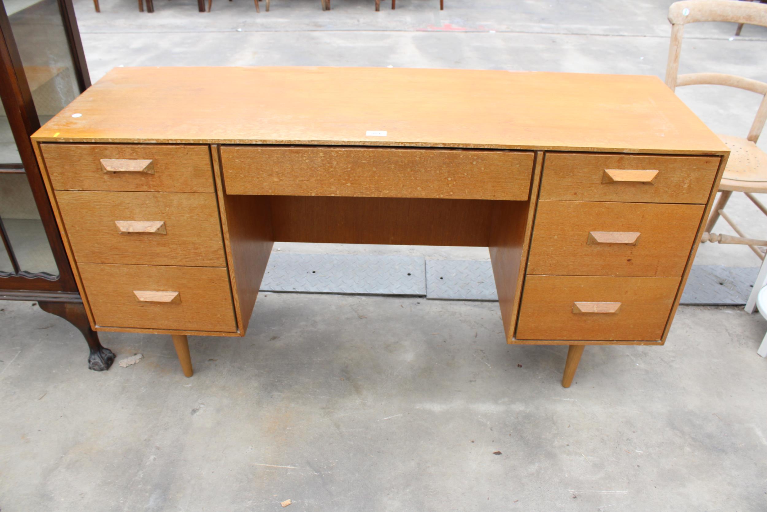 A RETRO TEAK STAG KNEE HOLE DRESSING TABLE ENCLOSING SEVEN DRAWERS, 53.5" WIDE