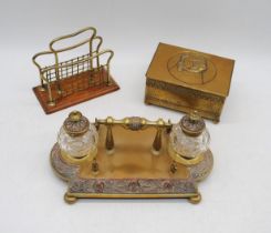 An antique brass twin inkwell on stand and pen rest, along with a brass cigarette box with