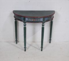 A painted demi lune table, with single drawer and carved detailing, raised on tapering reeded legs -