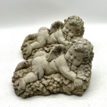 A pair of sleeping cherub garden ornaments. 30cm x 18cm, height 16cm