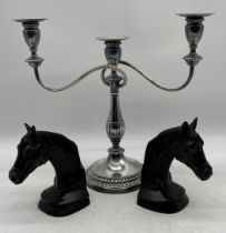 A pair of bronze bookends in the form of horses heads along with a silver plated three branch