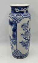 A large blue and white cylindrical Chinese vase with floral detail