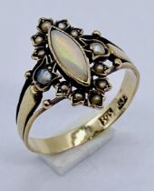 A Victorian 9ct gold ring set with an opal with a surround of seed pearls
