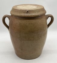 A large stoneware lidded jar with two handles, marked 15 to one side and A.N verso