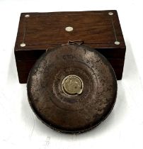 A vintage G.W.R. railway 100ft measuring tape along with a small wooden box.