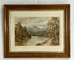 A framed watercolour painting of a lakeside forest with mountainous background. Overall size 63cm