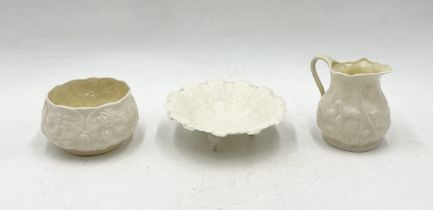 A Belleek sugar bowl and milk jug along with a Royal Worcester shell shaped pin dish on tripod legs