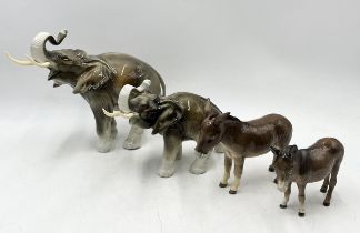 Two Beswick donkeys together with two Royal Dux elephants (A/F)