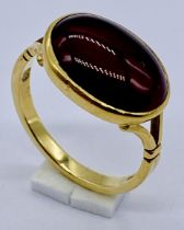 An 18ct gold ring set with a cabochon garnet, size L