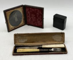 A small framed daguerreotype along with a hallmarked silver travelling cutlery set and a leather