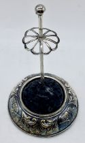 A silver hatpin stand decorated with cherubs