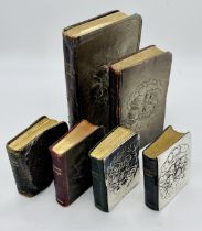 A collection of prayer books all with hallmarked silver covers decorated with cherubs