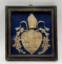 A small framed Victorian cut paper picture of a coat of arms