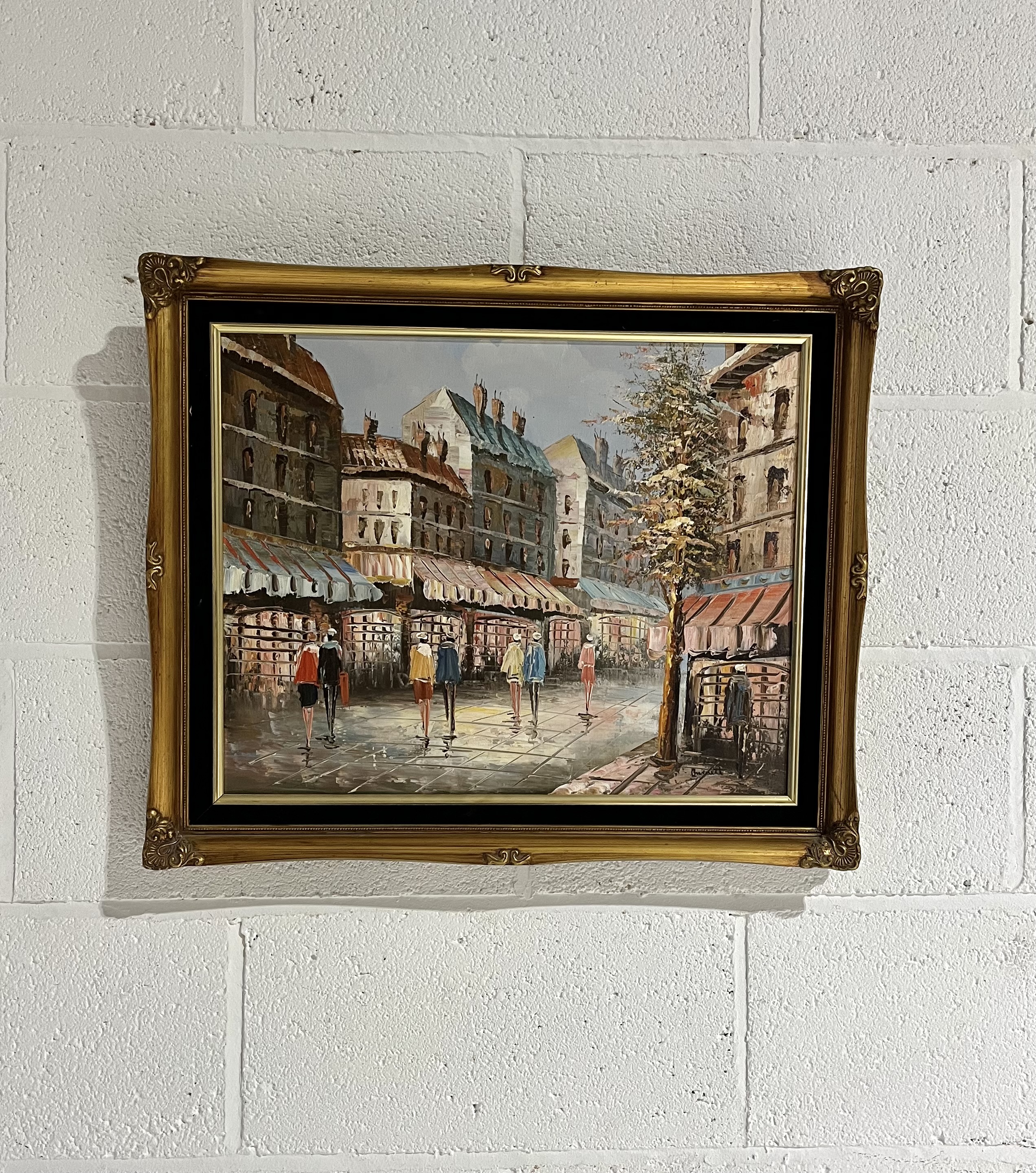 A gilt framed oil on canvas of people strolling along a Parisian street, signed Burnett