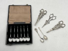 A cased set of silver plated bean spoons along with three pairs of grape scissors and two small