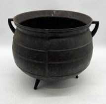 A twin handled cast iron 10 gallon cauldron on tripod legs