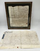 A framed part of an 18th century indenture along with another loose example