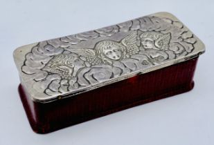 A small leather box with silver lid decorated with cherubs