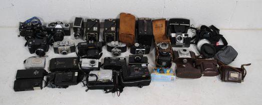 A collection of various cameras, including Canon T80, Brownie box cameras, Praktica, Flexora,