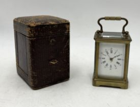 A miniature brass carriage clock with lined leather case and key