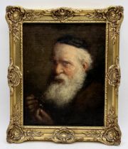 A small 19th century oil on board portrait of an older gentleman holding a ring and glasses,