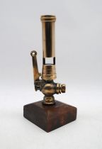 A brass steam whistle, mounted on a wooden stand, Height 28cm